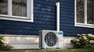 MRCOOL DIY mini split condenser beside rustic home in winter